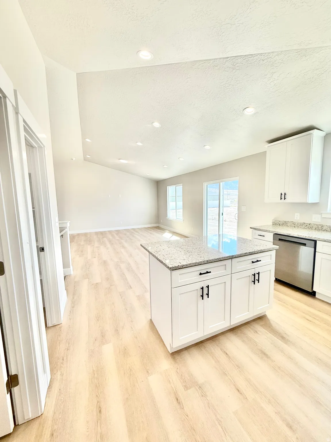 Kitchen with a center island, recessed lighting, light wood-style floors, dishwasher, and white cabinetry