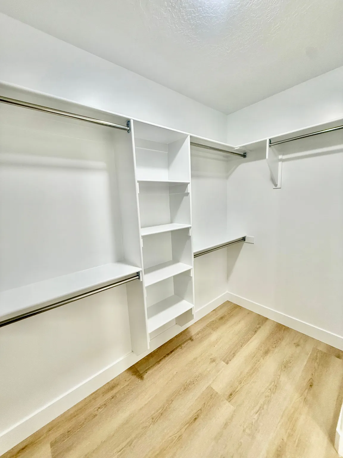 Walk in closet with light wood-style flooring