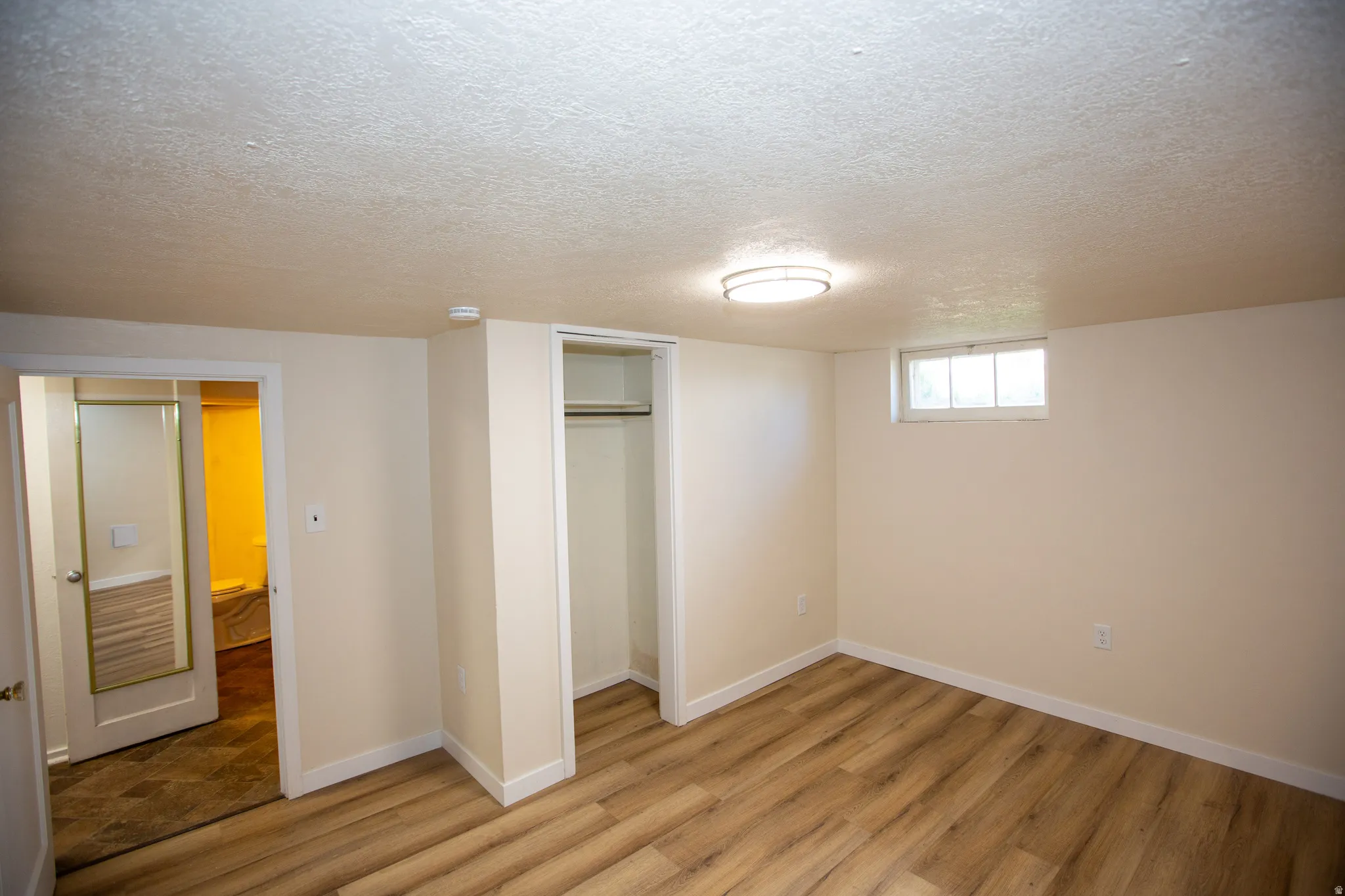 Bedroom with a textured ceiling, a closet, and LVP floors