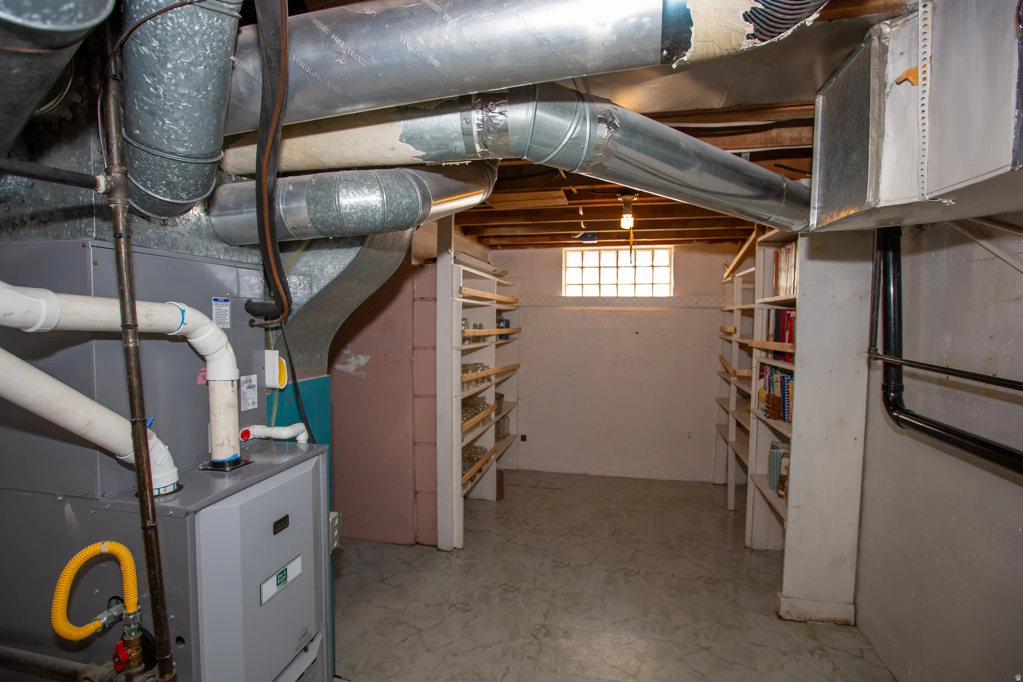 Basement storage/mechanical room featuring heating unit and light floors