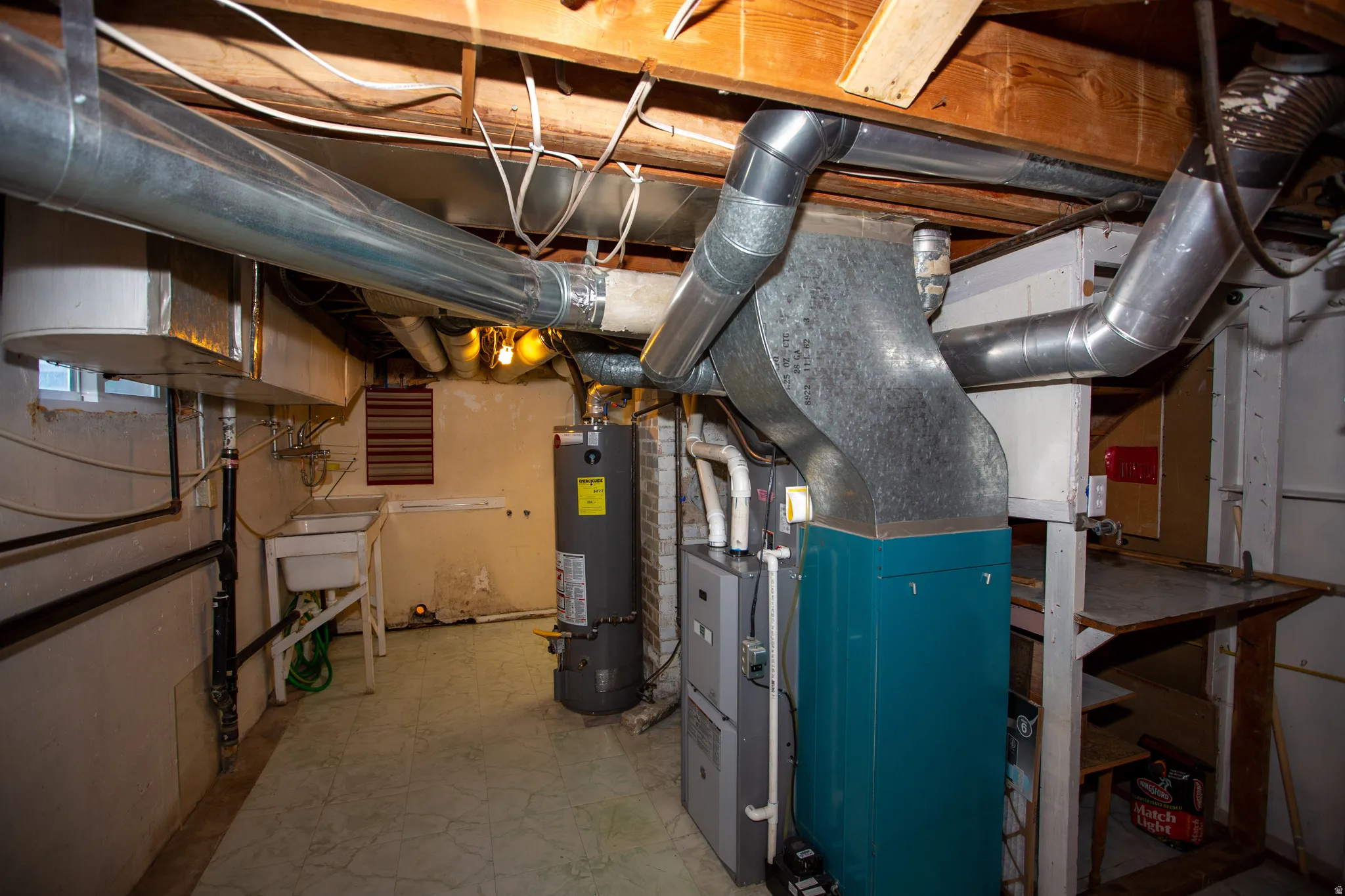 Basement storage/mechanical room with heating unit and gas water heater