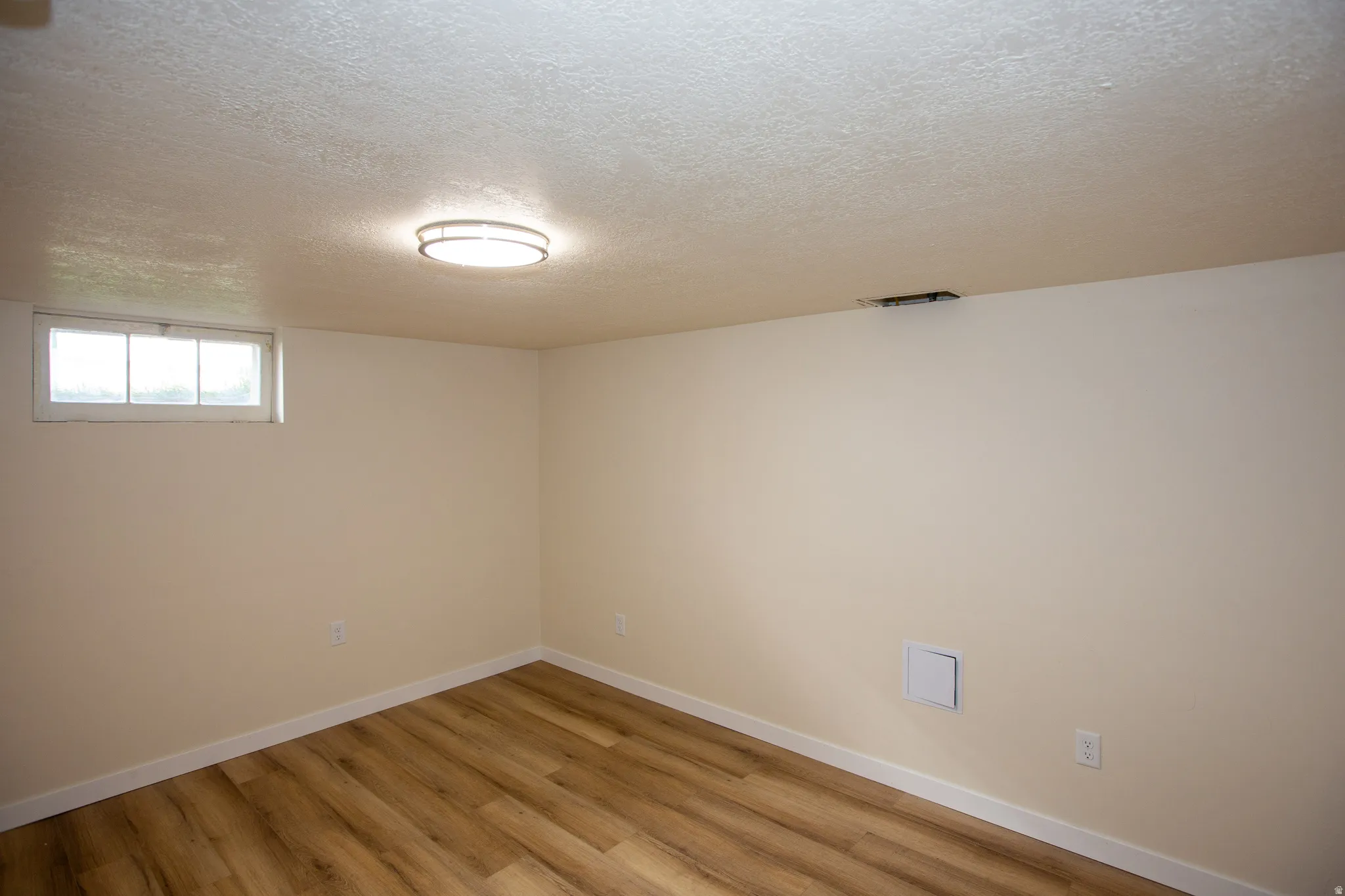Remodeled bedroom featuring a textured ceiling and LVP floors