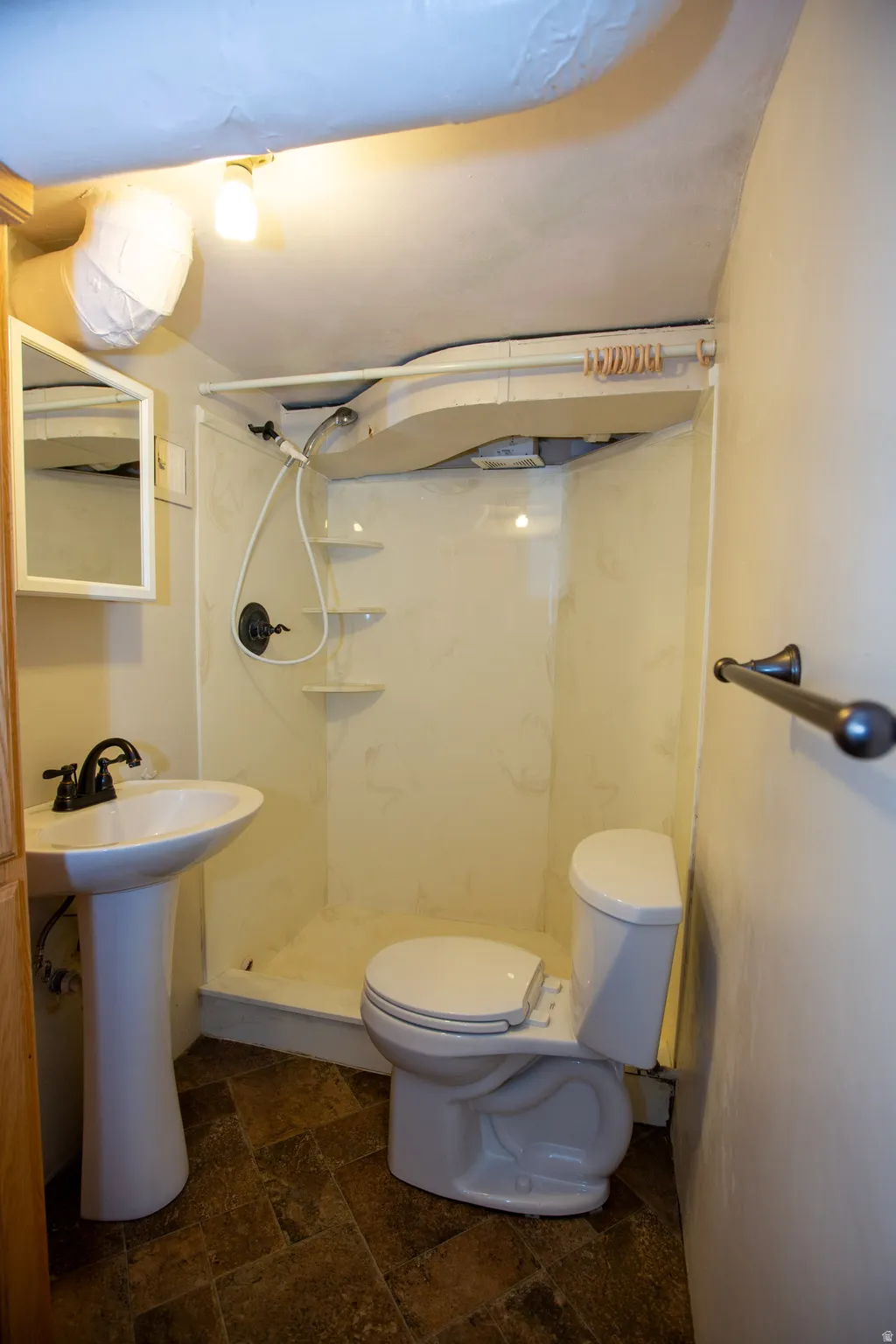 Bathroom with stone tile floors and a marble finish shower