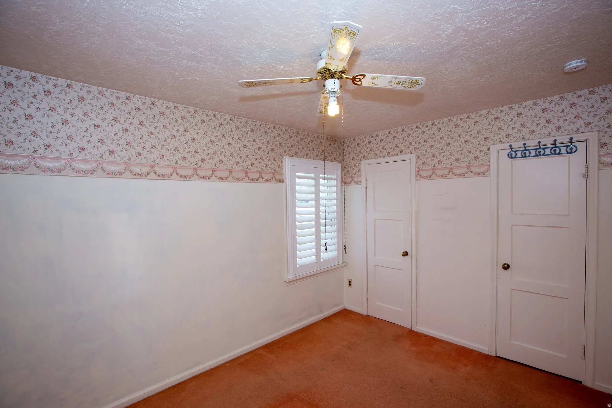 Unfurnished bedroom with a textured ceiling, carpet, a closet, and ceiling fan