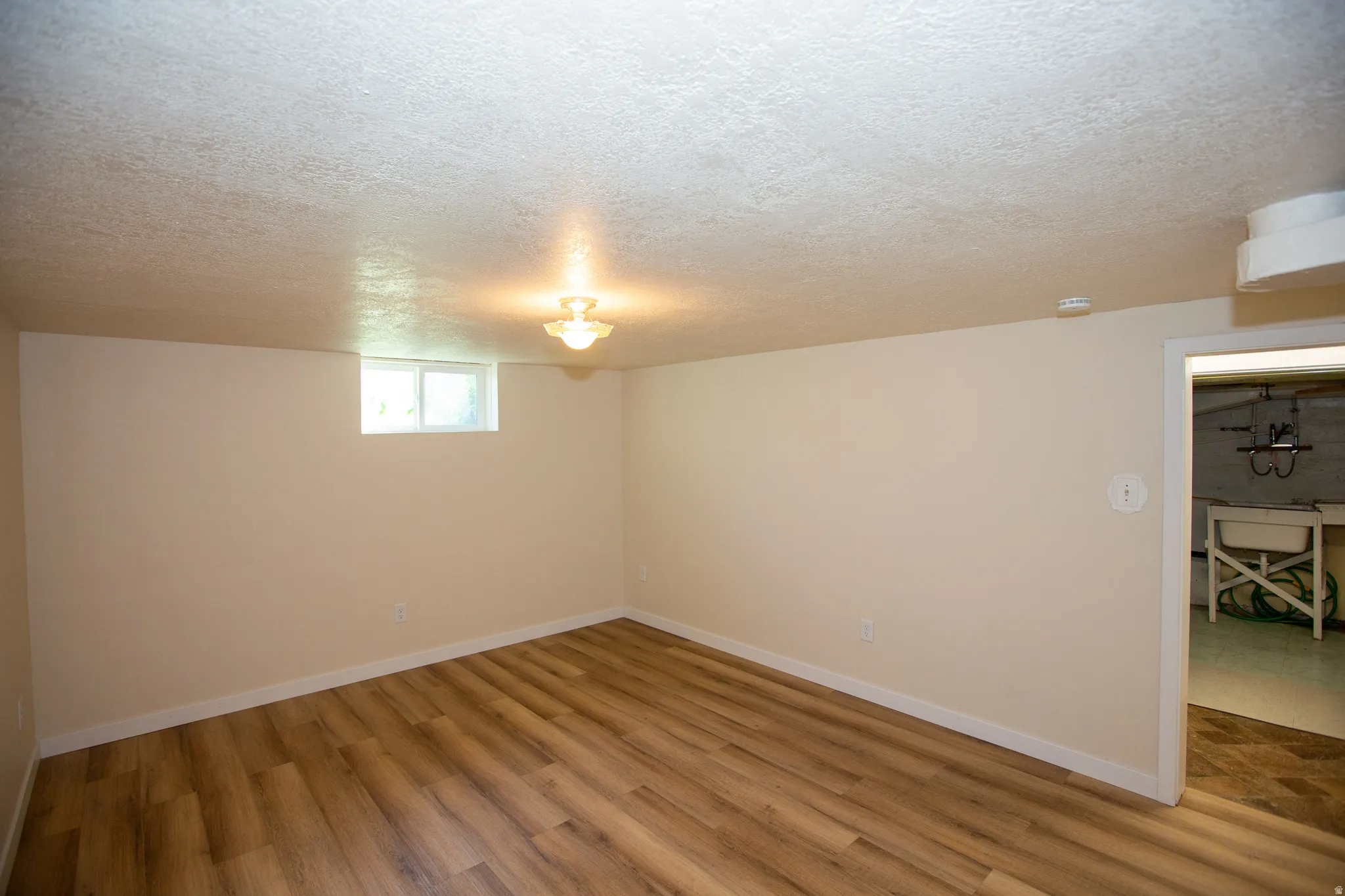 Bedroom with a textured ceiling and LVP floors