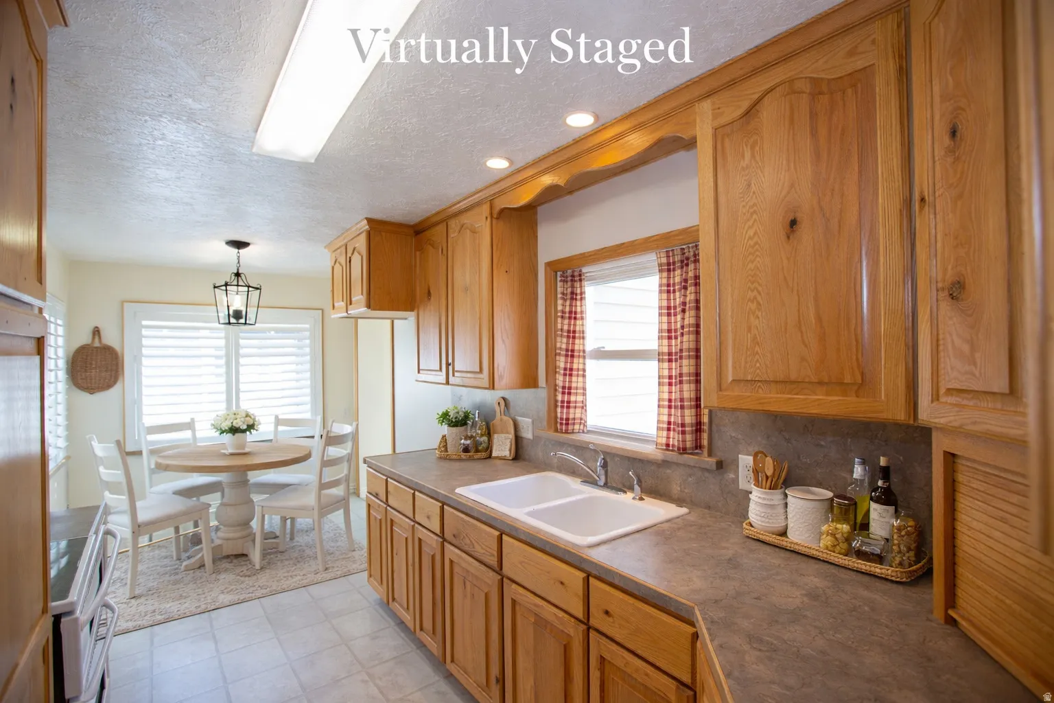 Virtual Staged - Kitchen with dark countertops, decorative light fixtures, a textured ceiling, backsplash, and wood finish cabinets