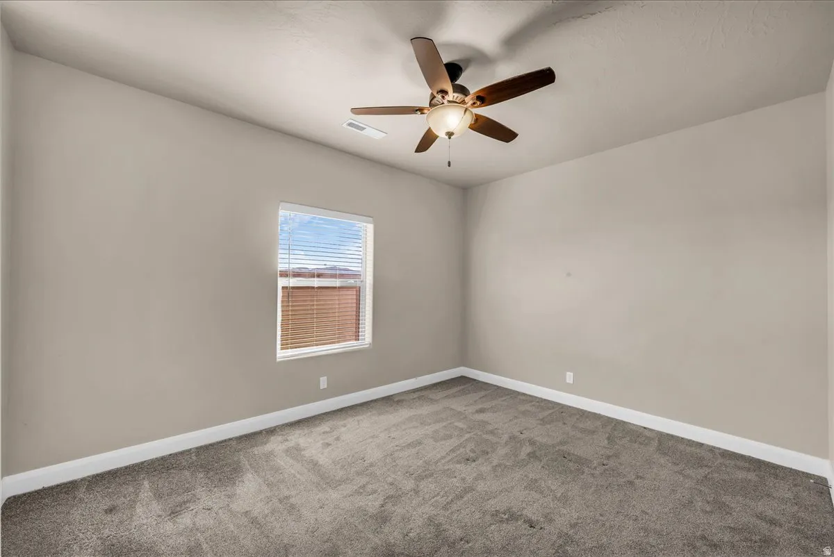 Spare room with light colored carpet and ceiling fan