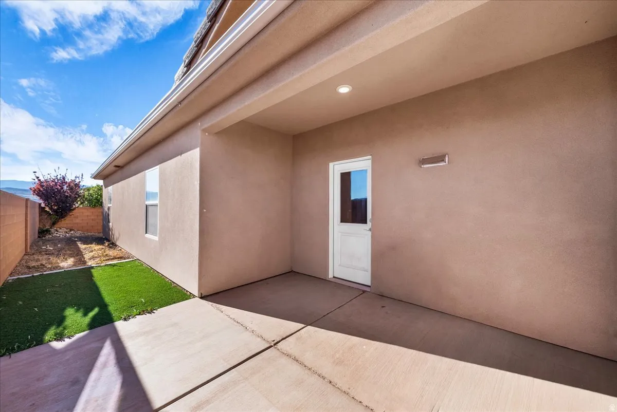 View of exterior entry featuring a patio and stucco siding
