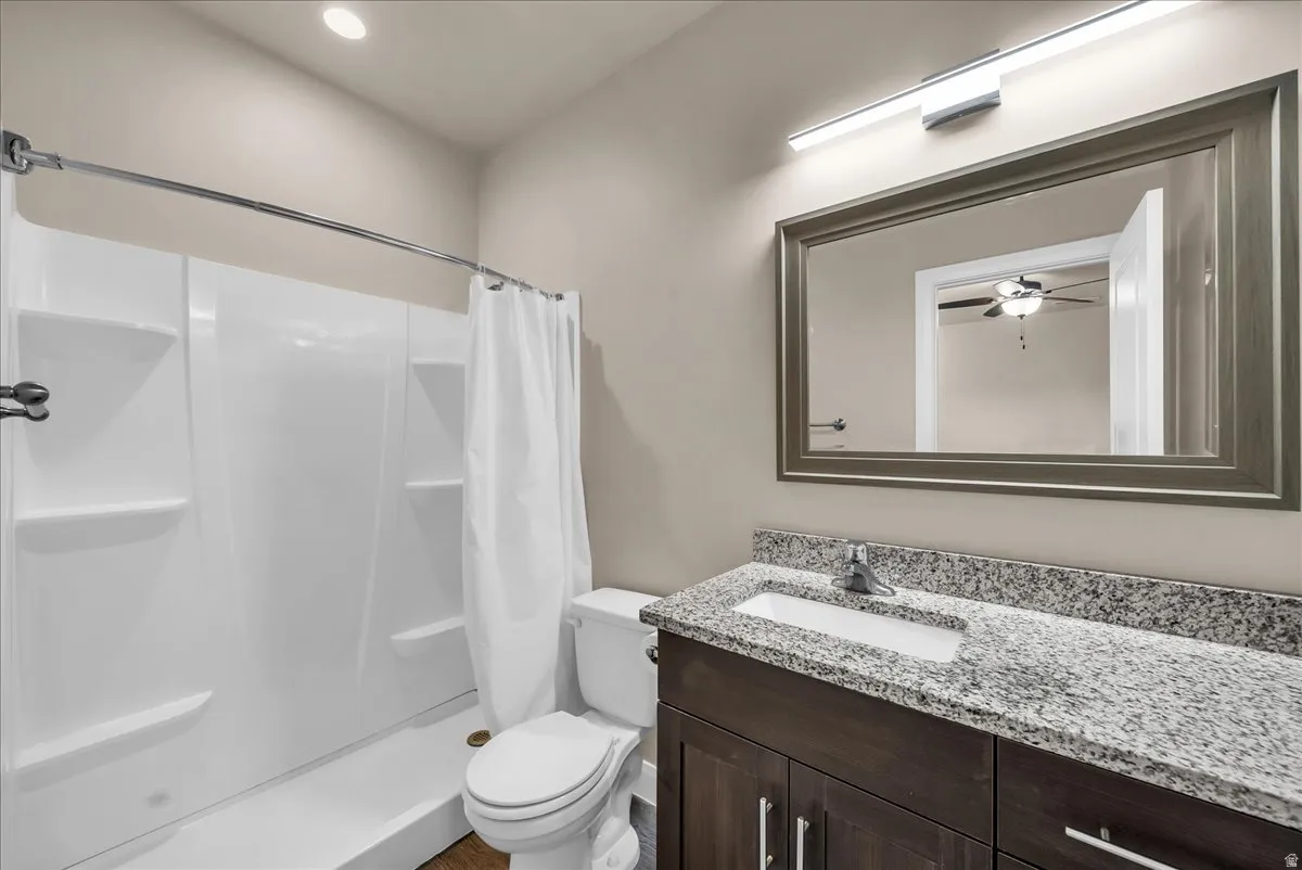 Bathroom with a shower stall, vanity, recessed lighting, and ceiling fan