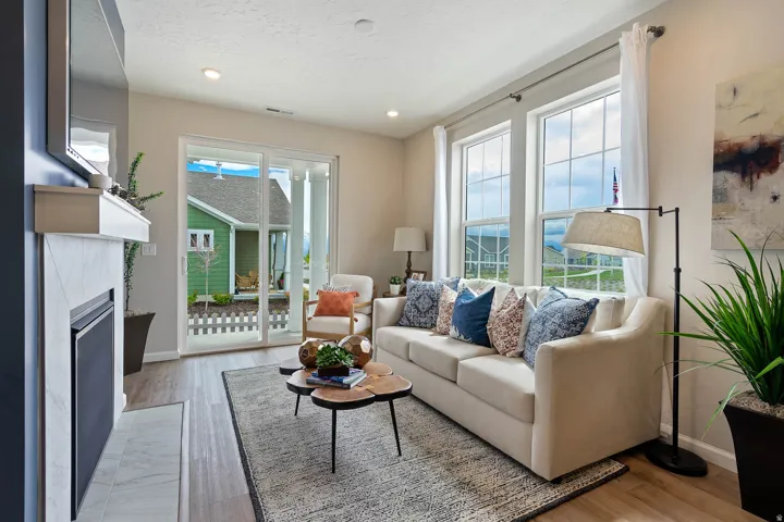Fireplace with mantel, wood-finish flooring, recessed lighting, and large windows with white trim