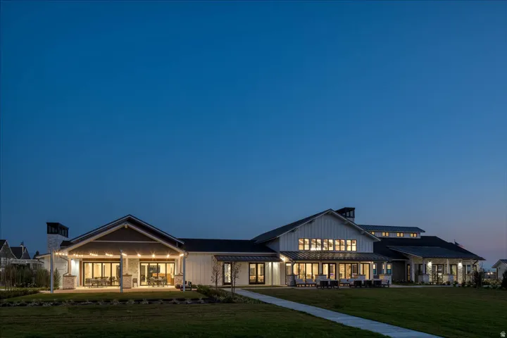 Modern farmhouse exterior featuring board and batten siding, stone facade, multiple gables, and a prominent chimney