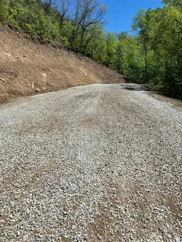 Gravel road surrounded by natural, wooded terrain