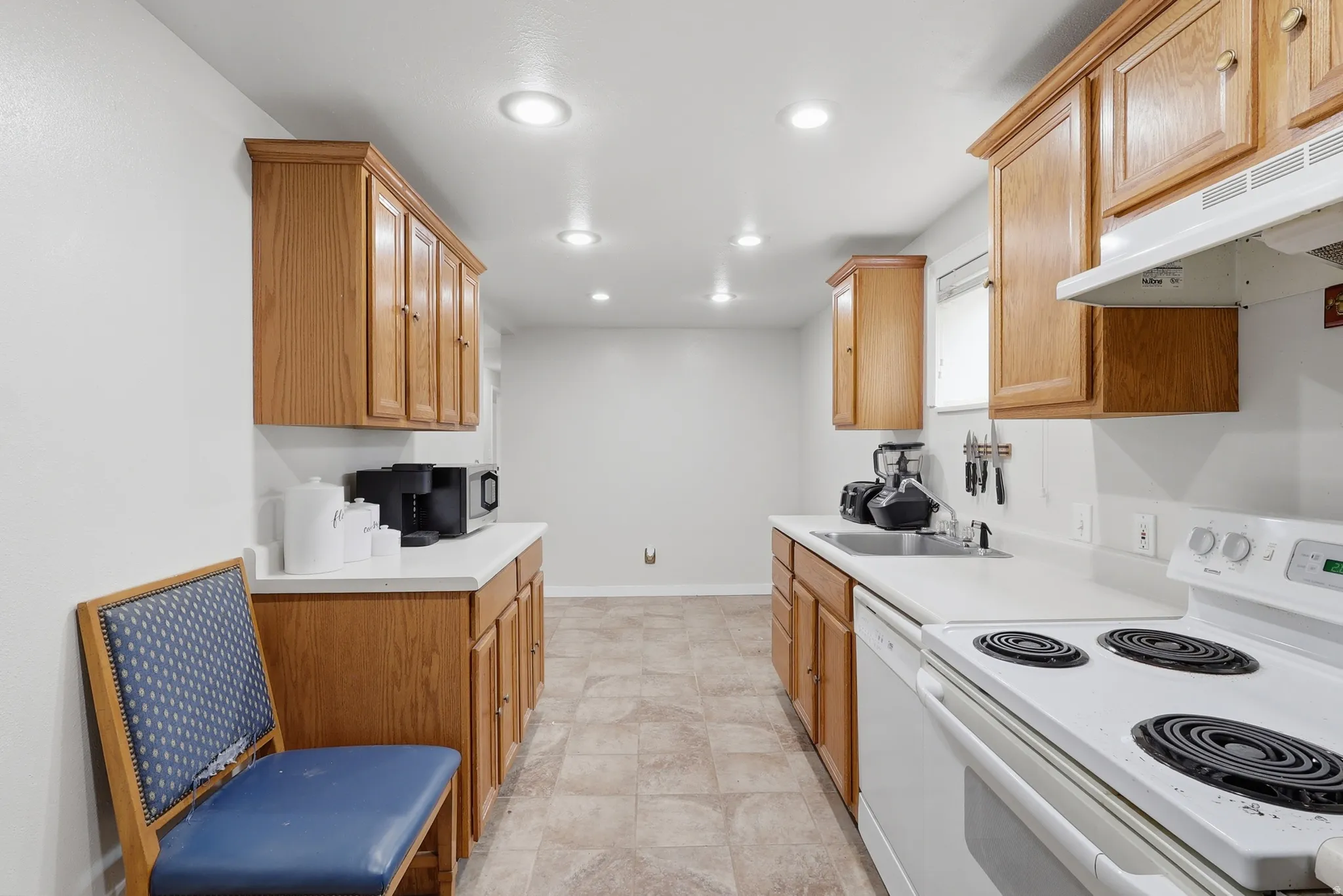 Kitchen with white appliances, light countertops, and recessed lighting