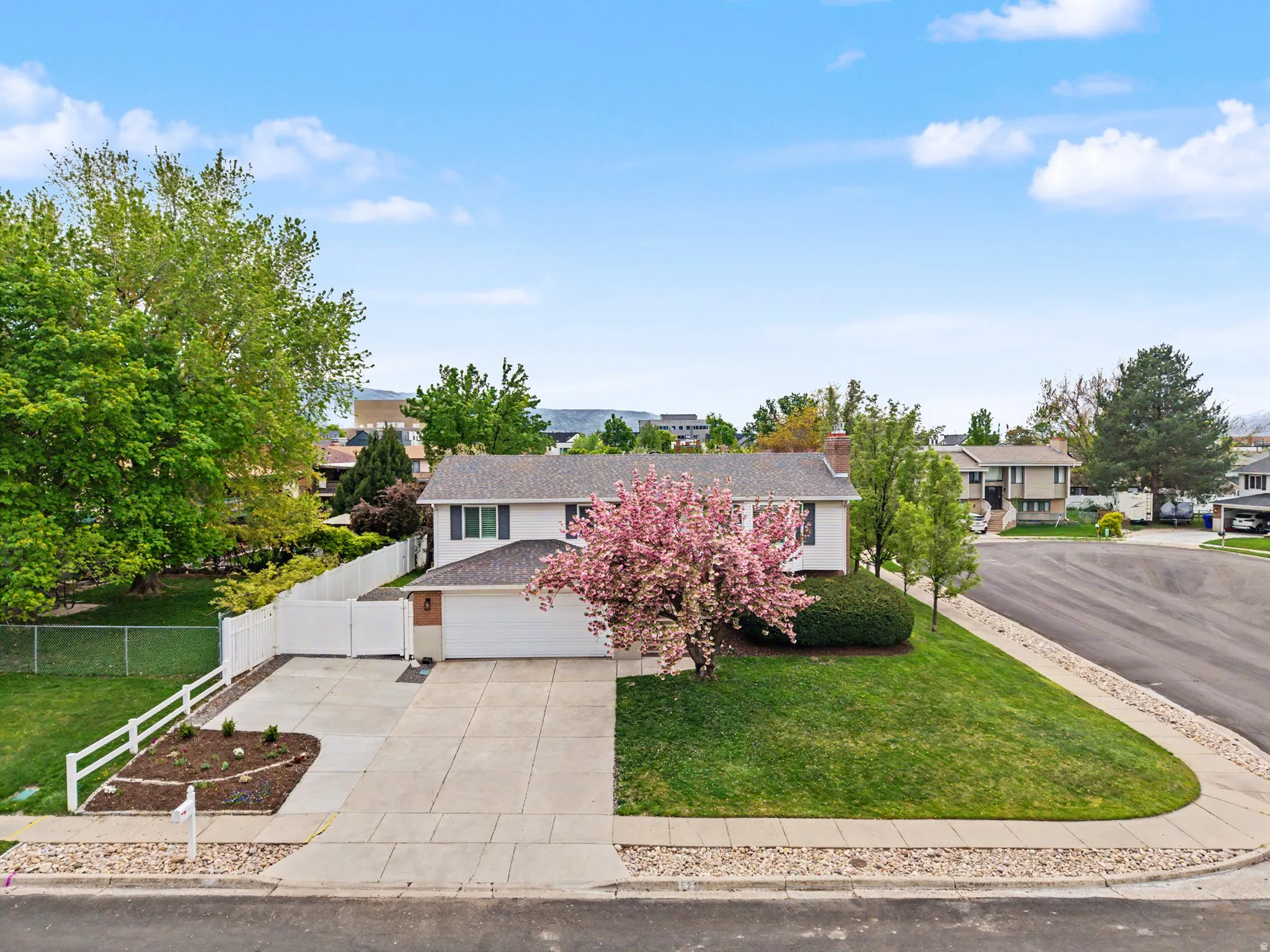View of front facade with concrete driveway, a shingled roof, and a residential view