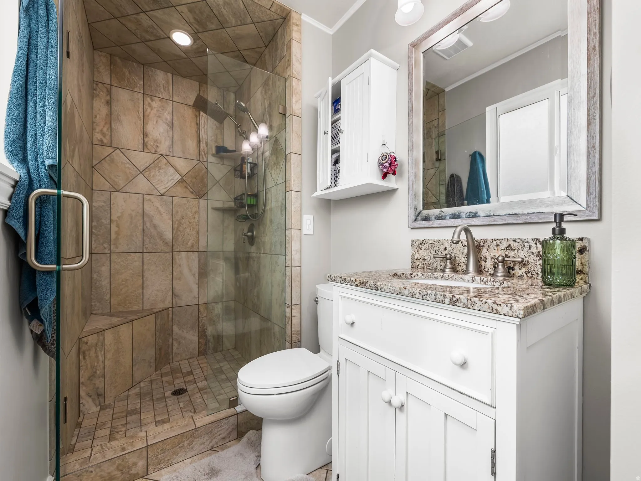 Full bathroom with vanity, a shower stall, and ornamental molding