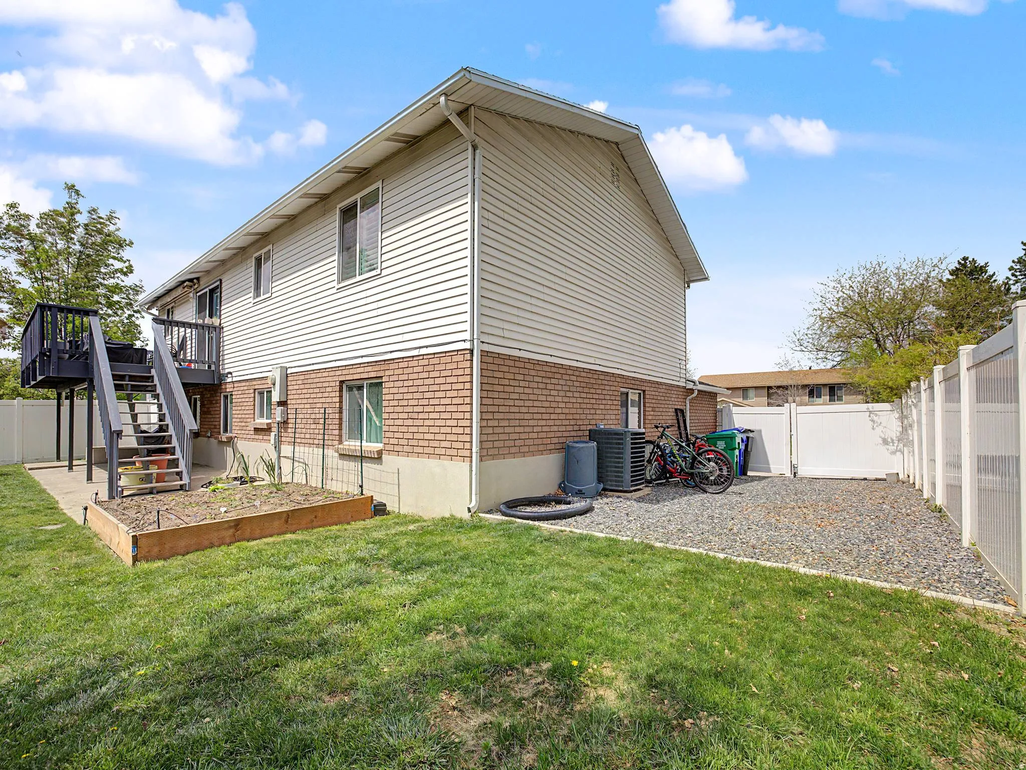 Rear view of property featuring a fenced backyard, brick siding, and a wooden deck