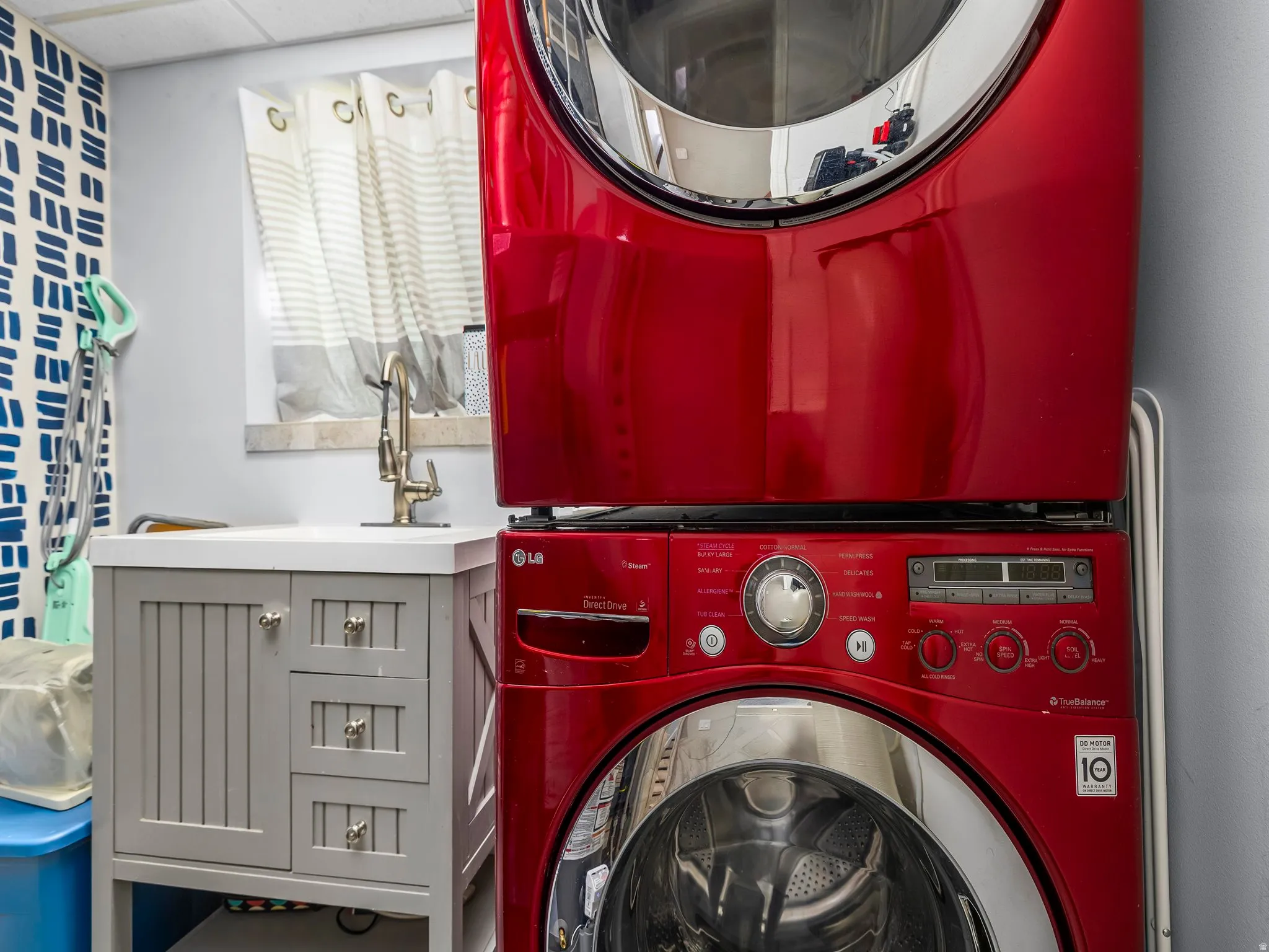 Laundry area featuring stacked washer / dryer and a sink