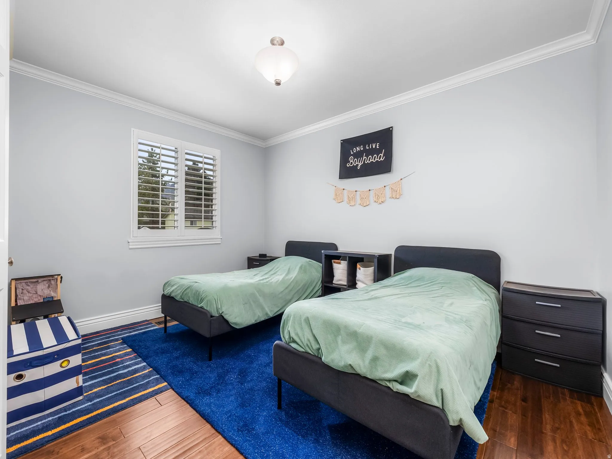 Bedroom featuring crown molding and dark wood finished floors