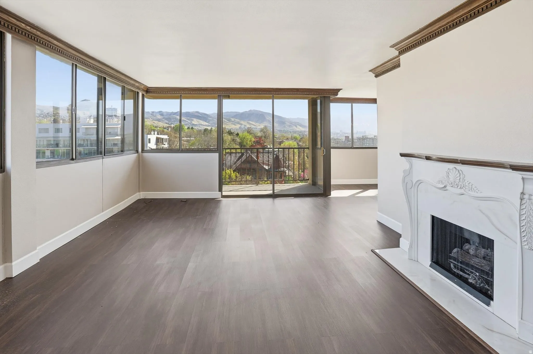 Unfurnished living room featuring a high end fireplace, dark wood finished floors, and a mountain view