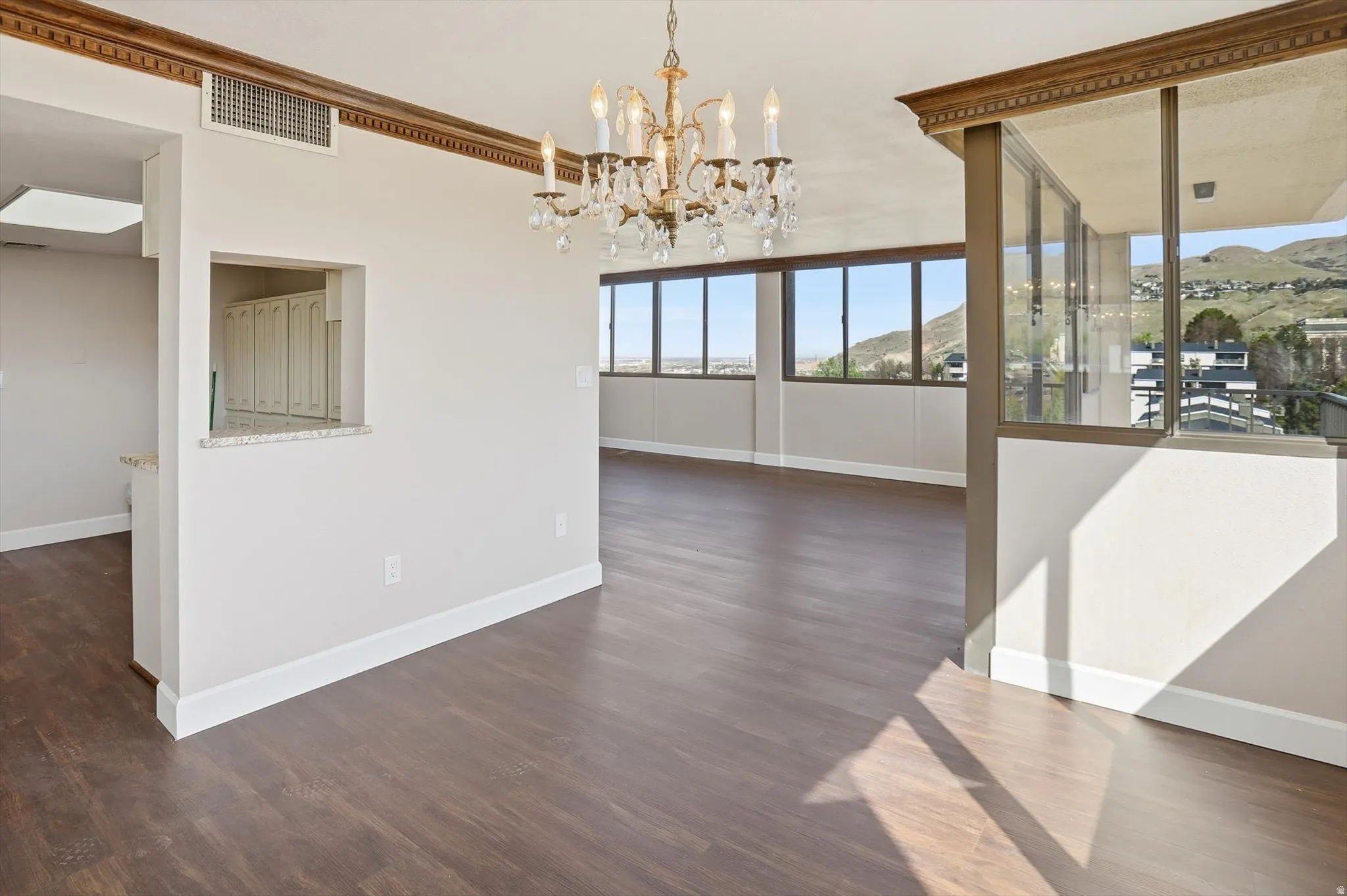 Unfurnished dining area with a chandelier, dark wood-style floors, and a mountain view