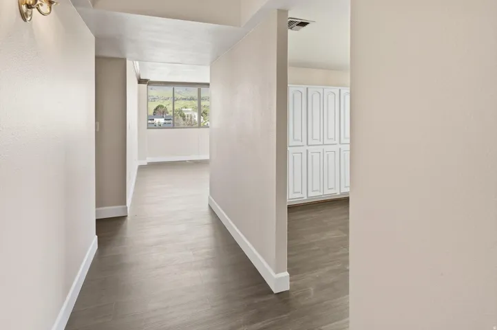 Hall with baseboards and dark wood-style flooring