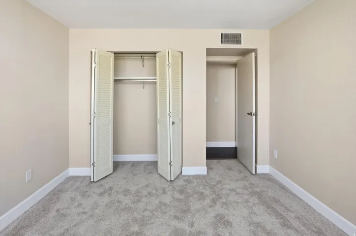 Unfurnished bedroom with light colored carpet and a closet
