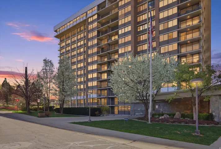 Property at dusk featuring a view of apartment building / complex
