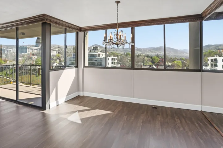 Unfurnished dining area featuring a chandelier, dark wood-style flooring, and healthy amount of natural light