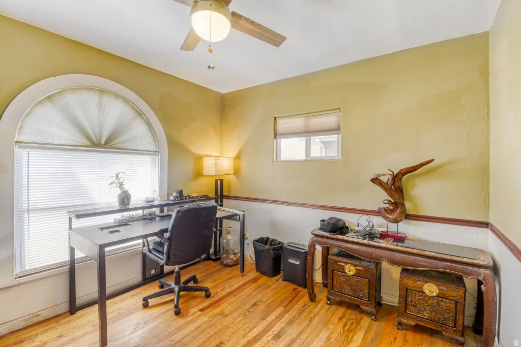 Office area featuring light wood-style floors and ceiling fan