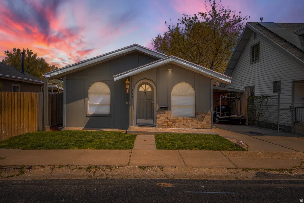 View of front of property with stone siding, board and batten siding, and a porch