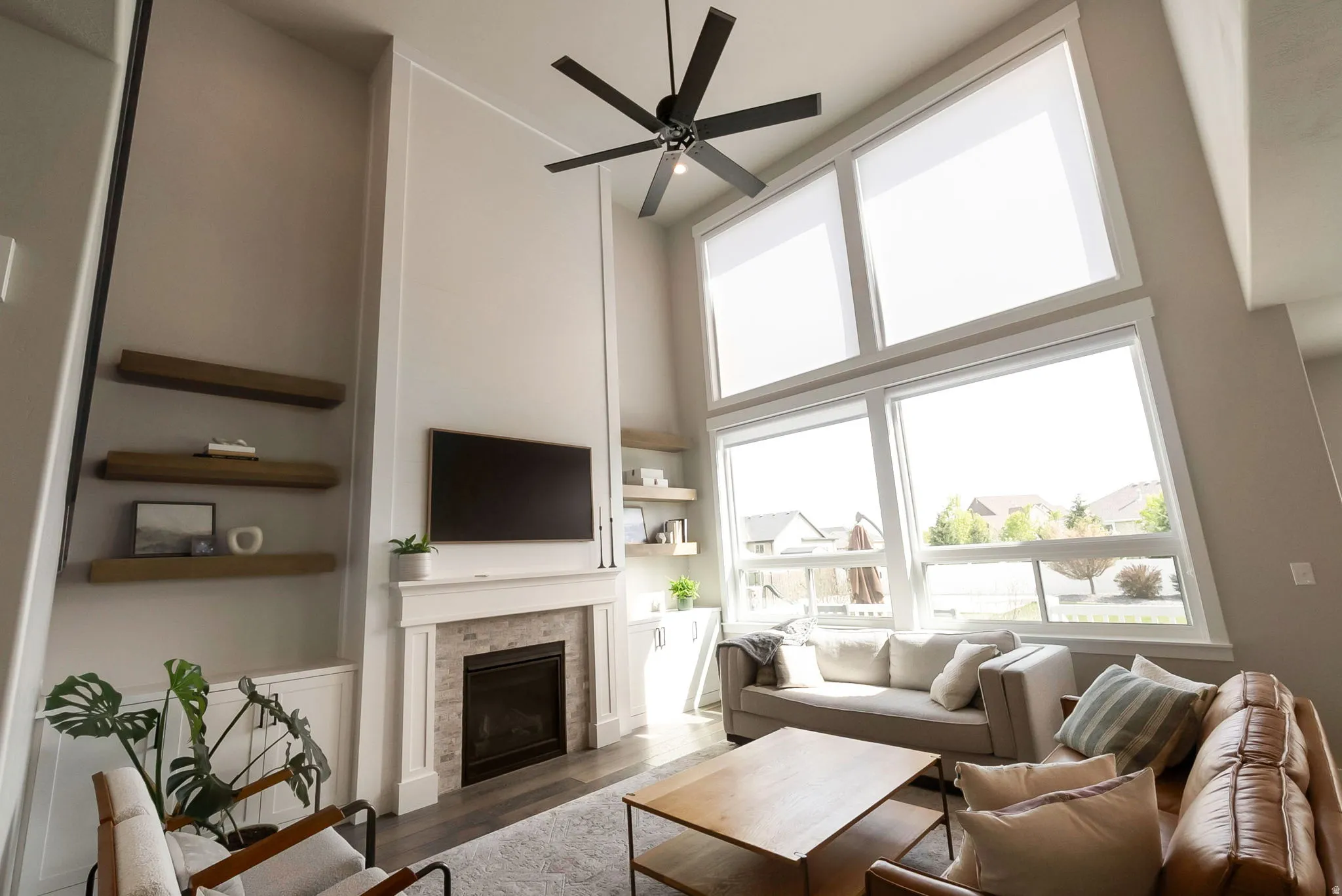 2-Story family room with so much natural light!  Cozy fireplace with custom cabinets and shelving.