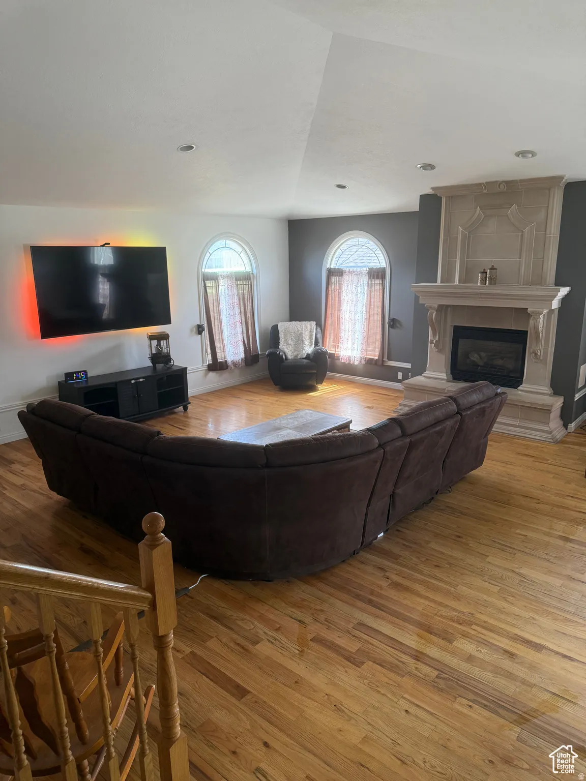 Massive 700 sf great room with light wood-style flooring, a fireplace, and lofted ceiling