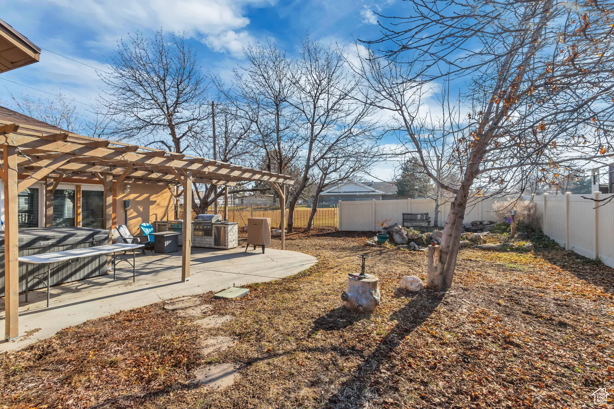 Fenced backyard with a pergola and a patio, outdoor kitchen and HOTTUB