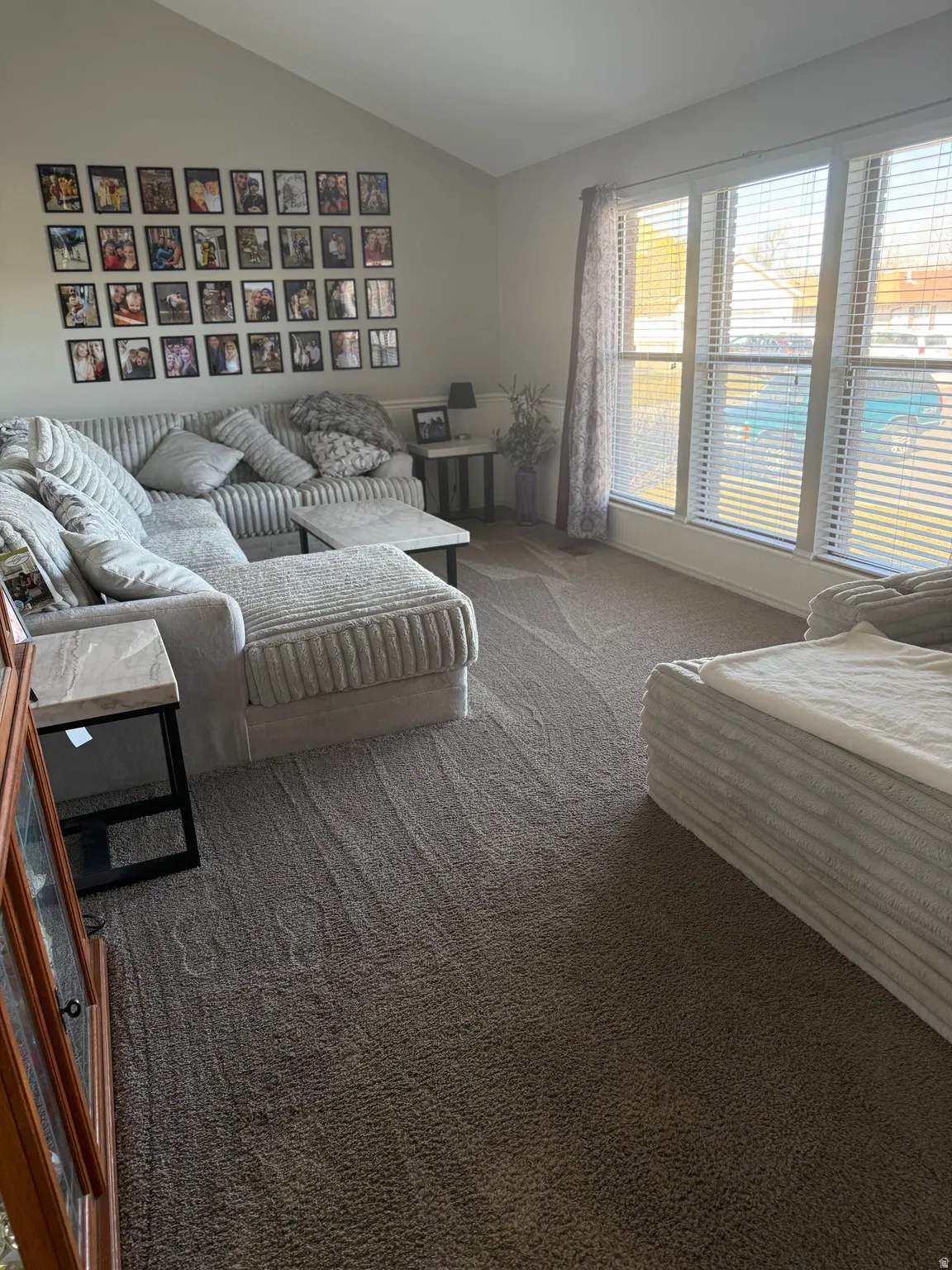 Carpeted front room featuring lofted ceiling