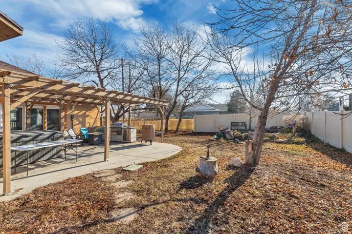 Fenced backyard with a pergola and a patio, outdoor kitchen and HOTTUB