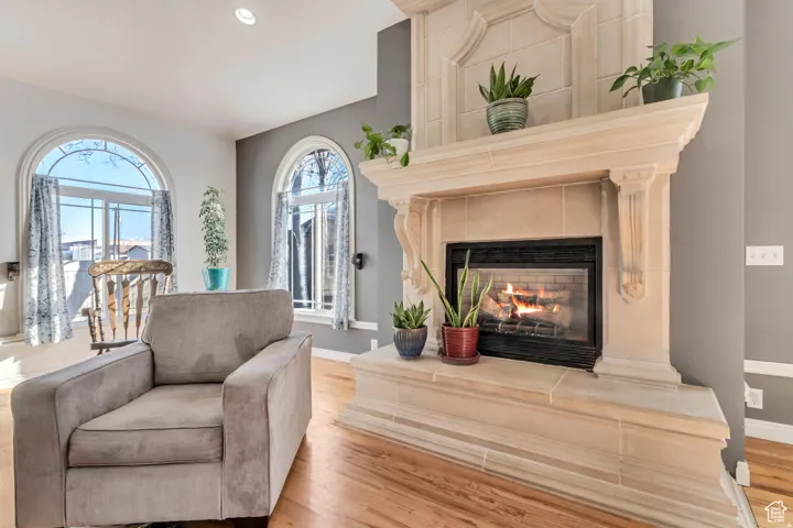 Wood-finish flooring with a decorative stone fireplace and mantle