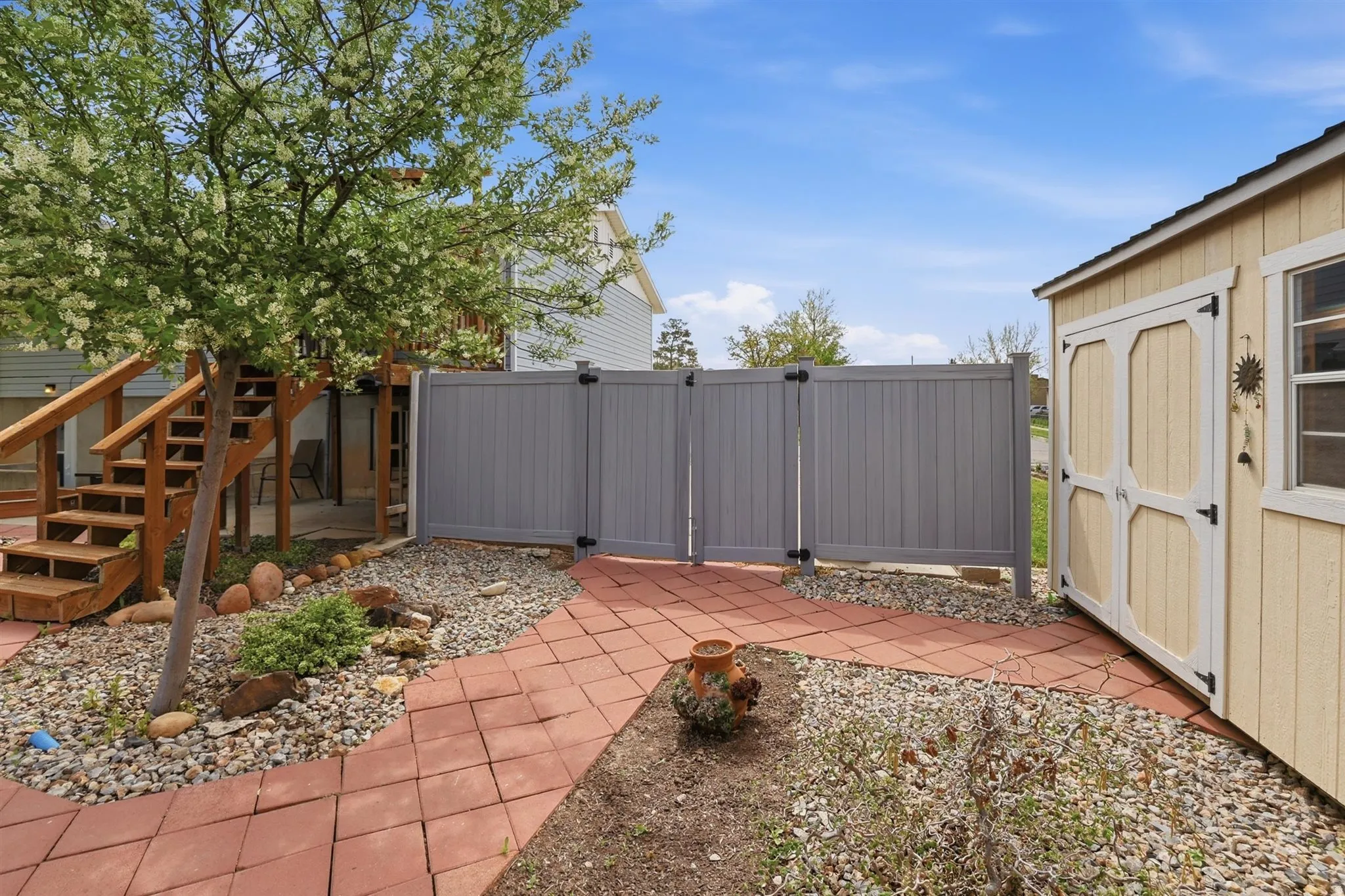 View of patio with a gate and a storage unit