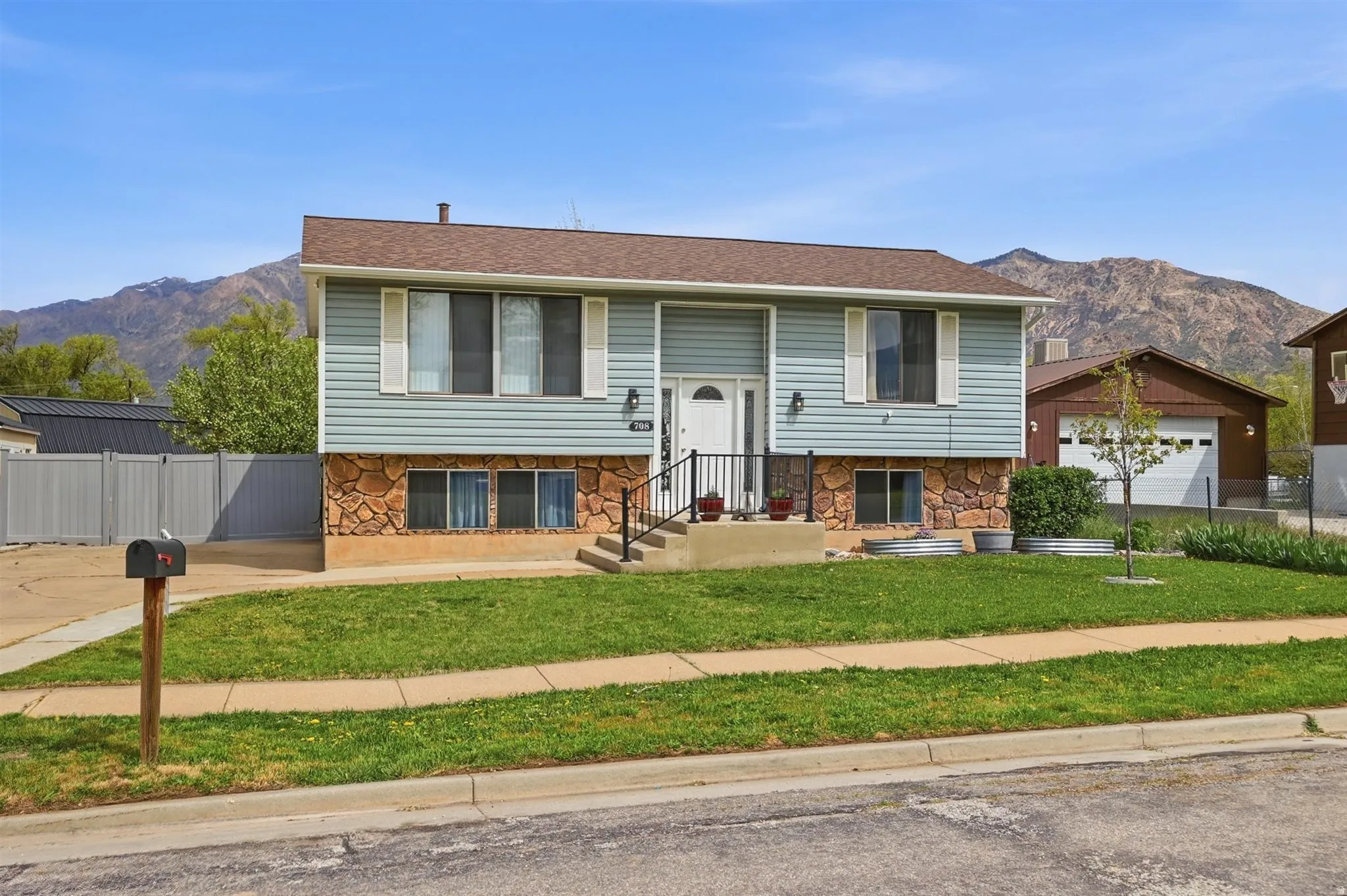 Split foyer home with a mountain view, stone siding, and a shingled roof