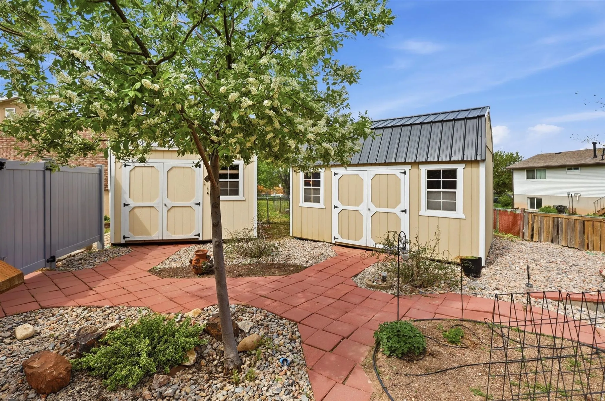 Fenced backyard featuring a storage unit