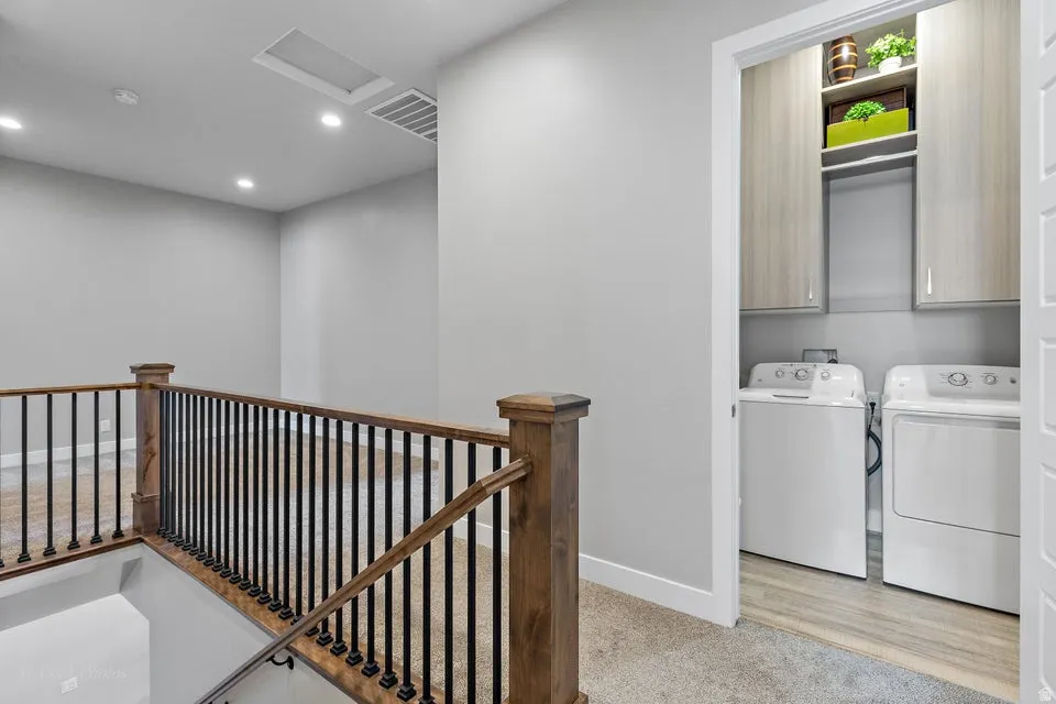 Laundry area with washer and clothes dryer, cabinet space, recessed lighting, and light carpet