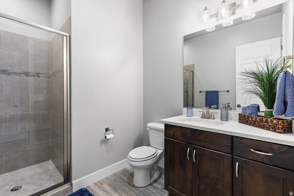 Bathroom featuring vanity, a stall shower, and light wood finished floors