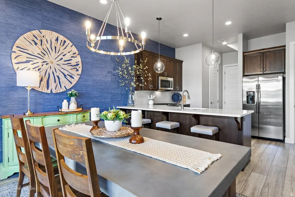 Dining space with light wood-style floors and suspended lighting
