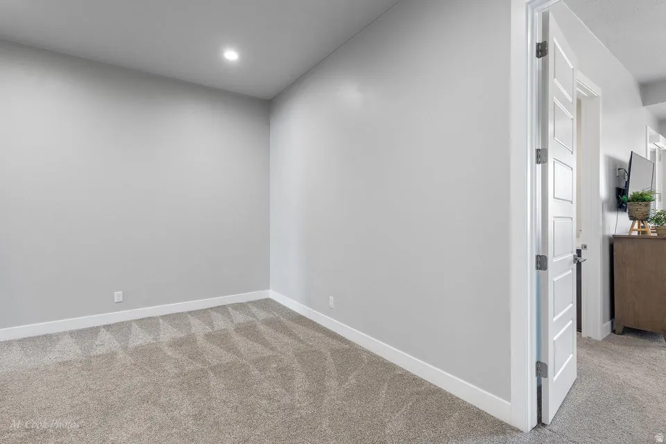 Empty room with light carpet and baseboards