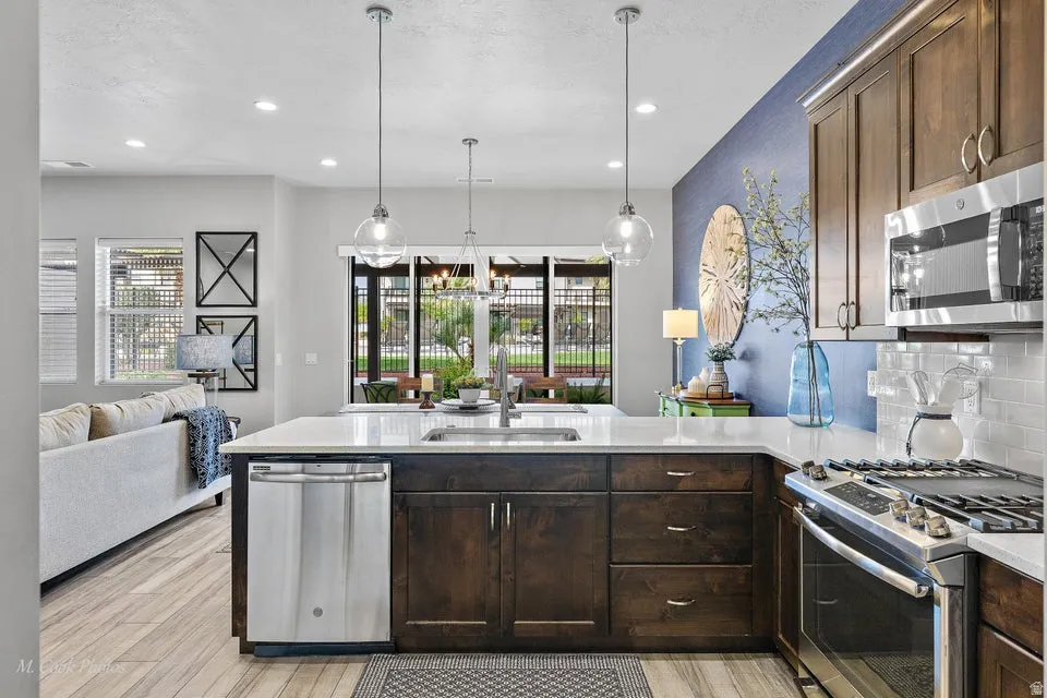 Kitchen with dark wood finish cabinetry, a peninsula, and stainless steel appliances