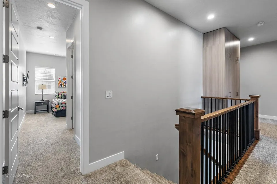 Hall with an upstairs landing, light carpet, and recessed lighting