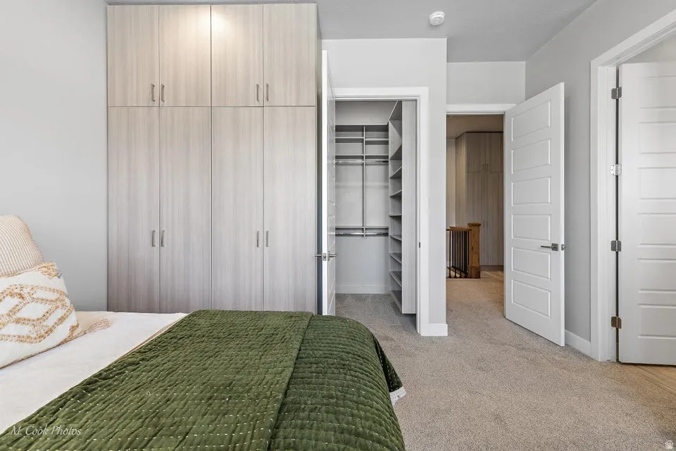 Bedroom featuring a spacious closet and light carpet
