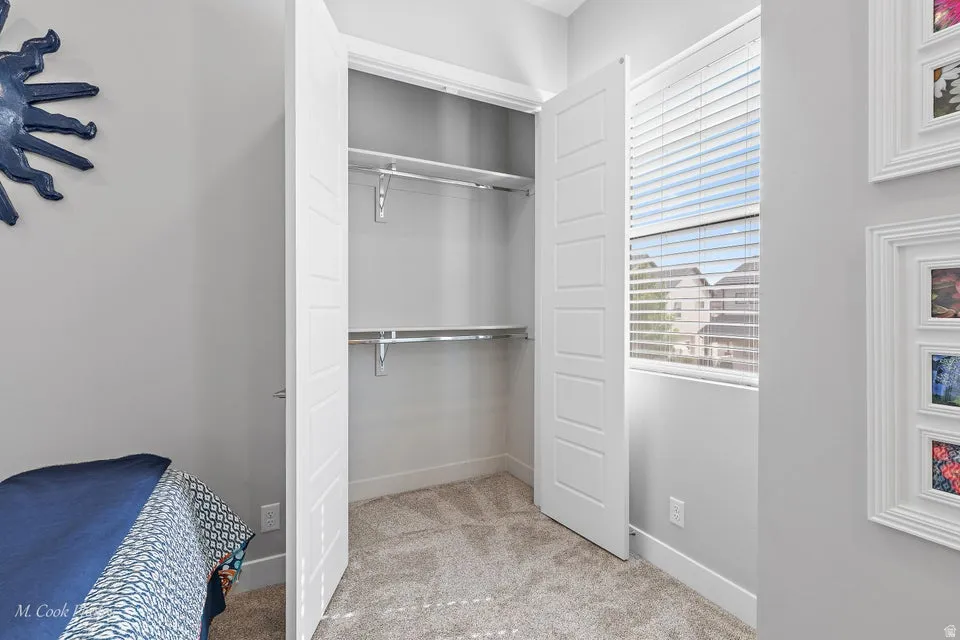 Bedroom featuring light colored carpet and a closet