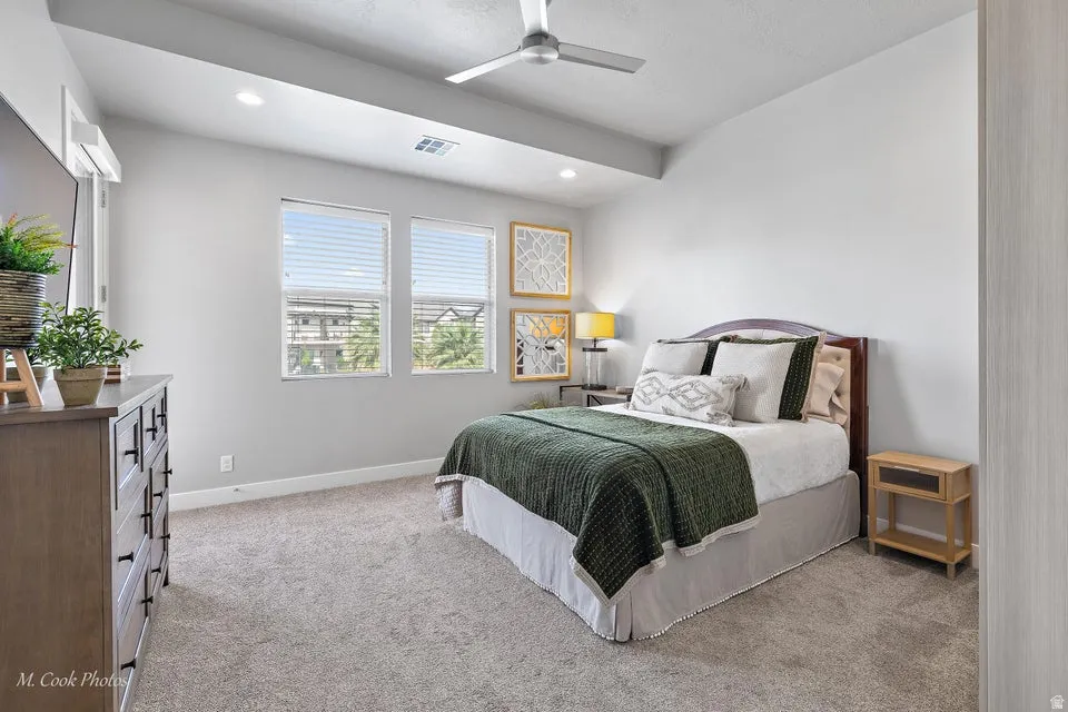 Bedroom with light colored carpet, ceiling fan, and recessed lighting