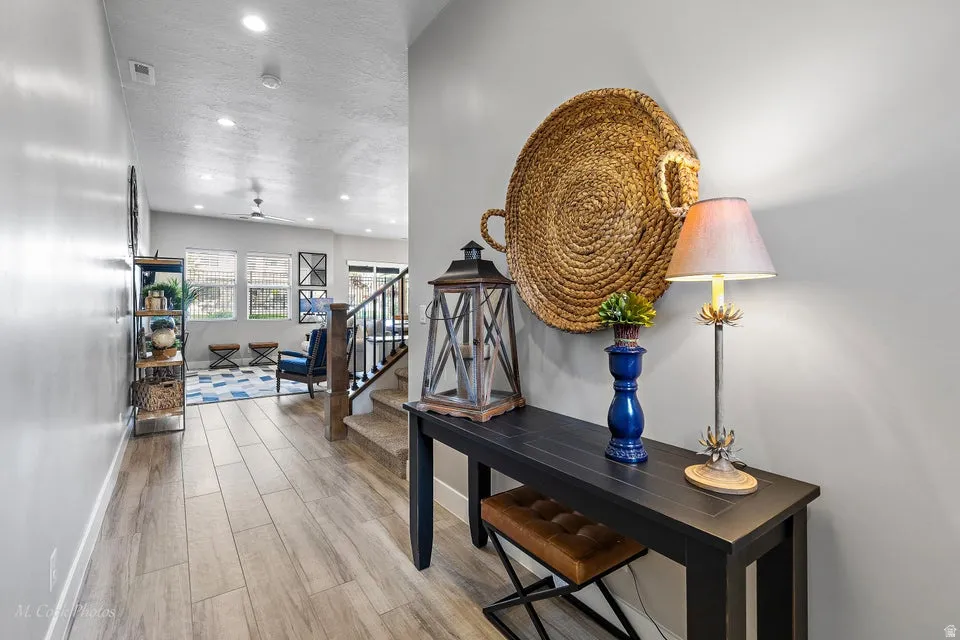Hallway with light wood-style flooring, recessed lighting, and a textured ceiling
