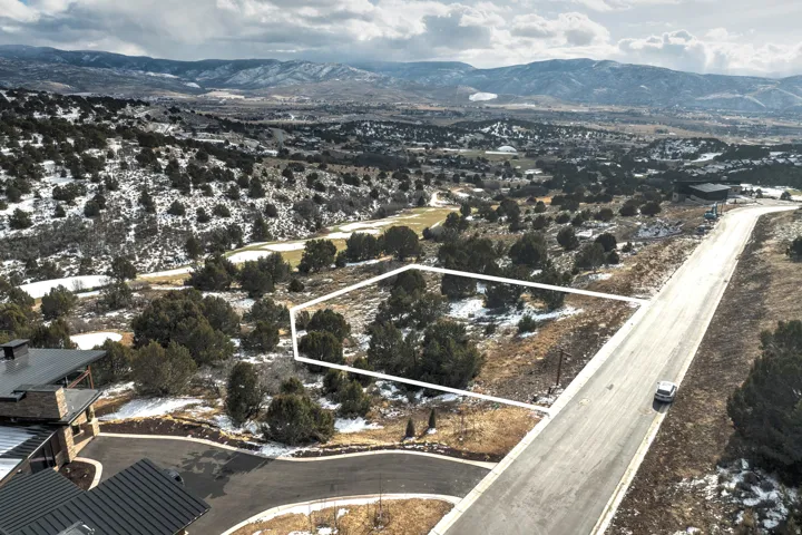 Aerial overview of property's location featuring a mountain backdrop and property boundaries highlighted